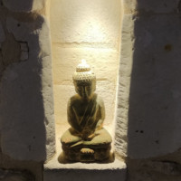 Statuette du Bouddha dans une niche lumineuse de la terrasse du restaurant La Rencontre à Montreuil-Bellay
