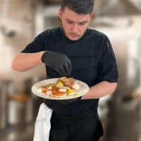 Le chef restaurateur Grégoire Nadeaud, apportant la touche finale à un plat du restaurant La Rencontre, à Montreuil-Bellay, Pays de la Loire.